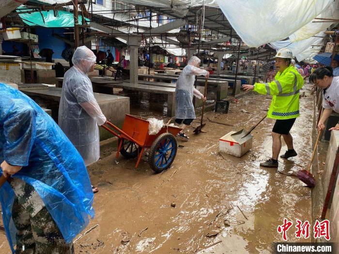 圖為7月26日，暴雨引發(fā)的洪水過境后，重慶萬州區(qū)分水鎮(zhèn)政府干部職工及志愿者清掃淤泥和垃圾?！　≈貞c萬州區(qū)委宣傳部供圖 攝