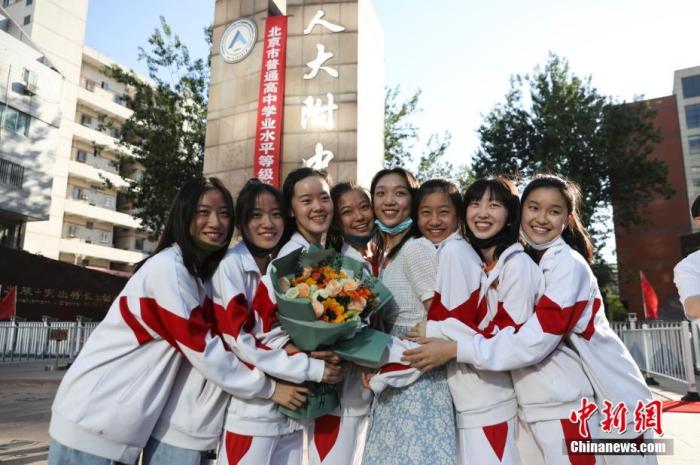 資料圖：6月10日，在北京人大附中高考考點(diǎn)外，考生們相擁拍照留念。當(dāng)日，北京市2021年高考結(jié)束?！?<a target='_blank'  data-cke-saved- ><p  align=